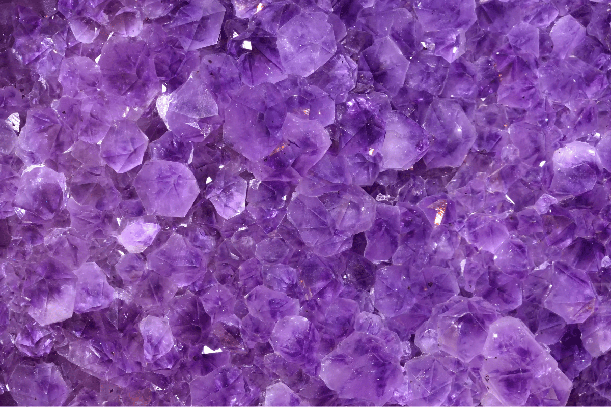Close-up of vibrant purple amethyst crystals showcasing their natural facets and shimmering texture.