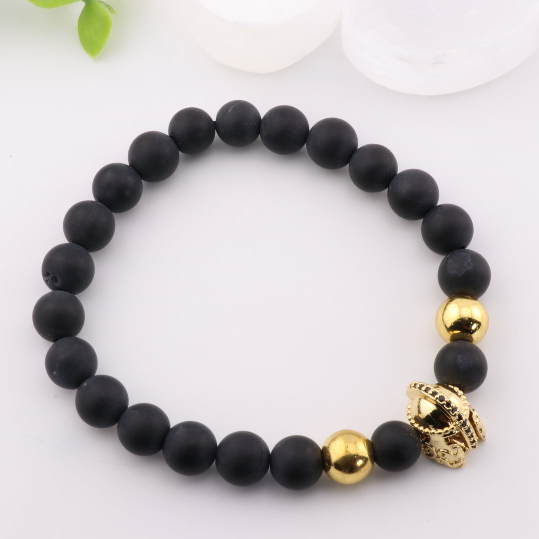Pulsera de ónix natural esmerilado: elegancia artesanal con detalle de casco antiguo dorado y cuentas de 8 mm.