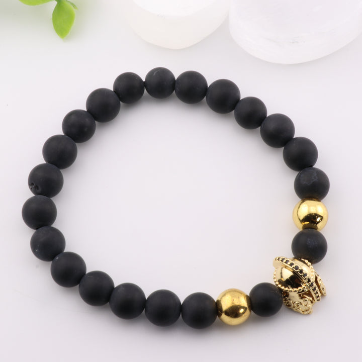 Pulsera de ónix natural esmerilado: elegancia artesanal con detalle de casco antiguo dorado y cuentas de 8 mm.