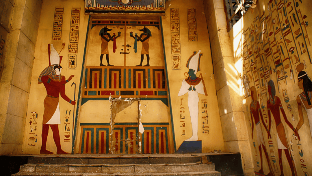 Colorful ancient Egyptian wall mural featuring hieroglyphics and deities including Osiris, Anubis, and Ra, within a sacred temple interior illuminated by soft sunlight.