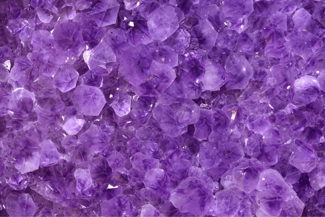 Close-up of vibrant purple amethyst crystals showcasing their natural facets and shimmering texture.