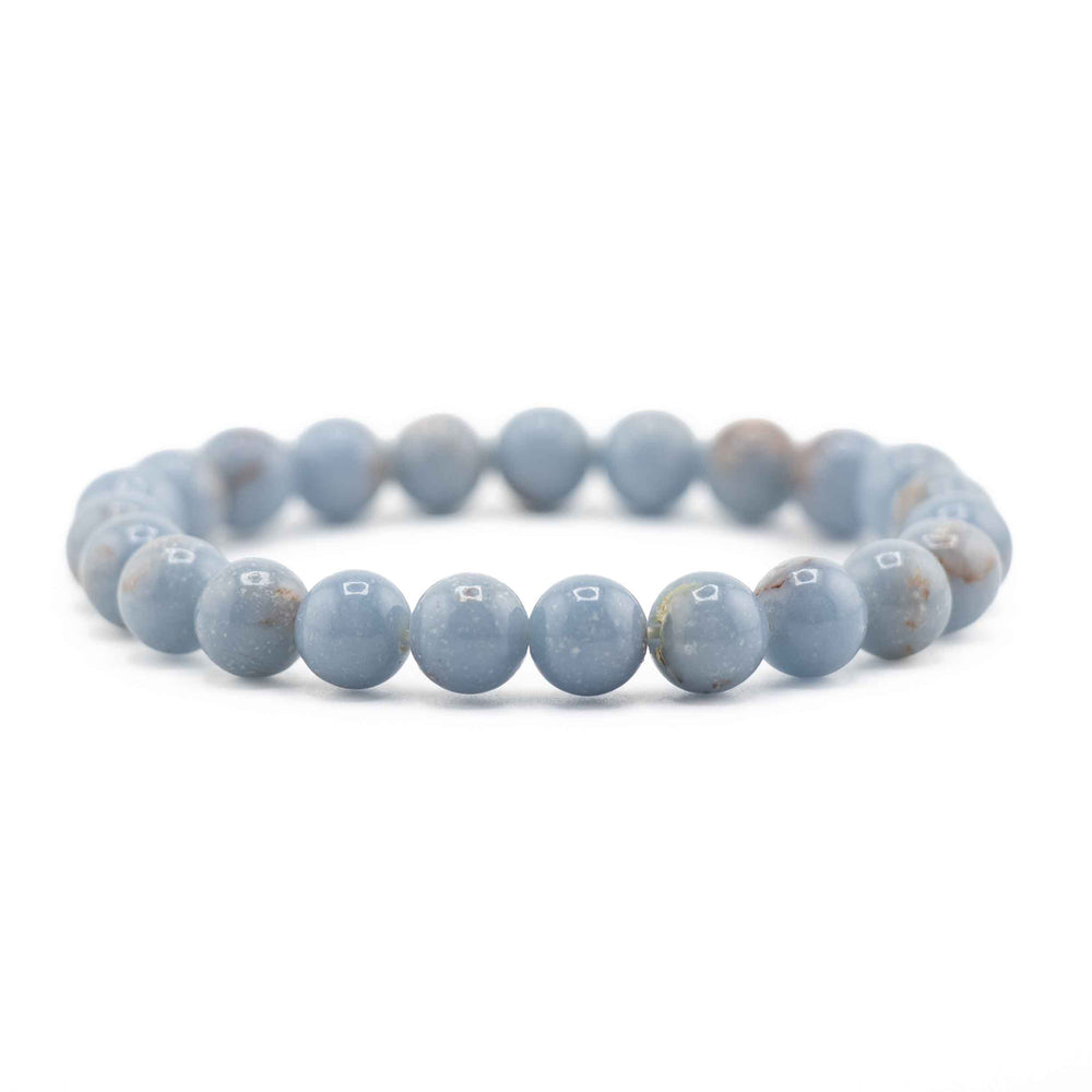 Side view resting shot of an Angelite gemstone beaded stretch bracelet lying flat on a white background