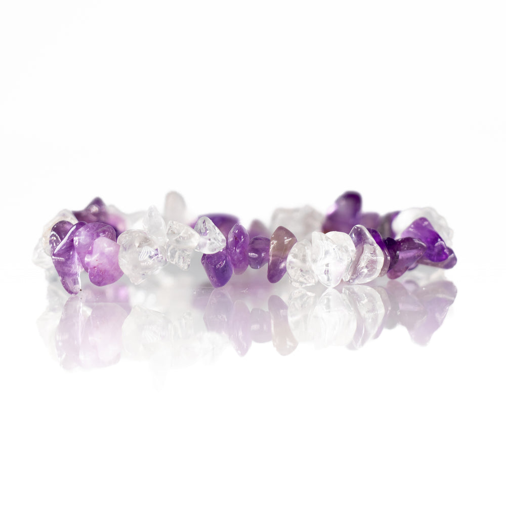 Handcrafted bracelet featuring tumbled amethyst and clear quartz chips elegantly displayed on a reflective white surface
