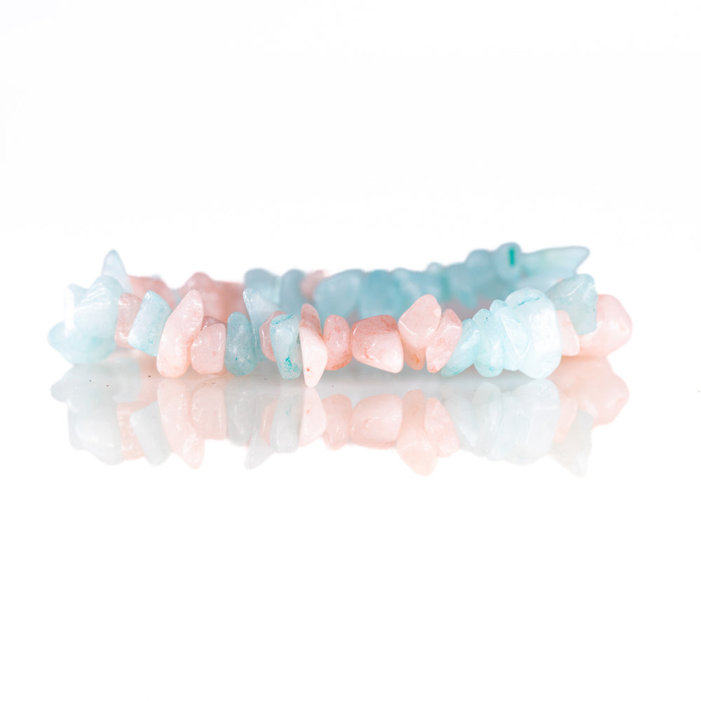 Two chip gemstone bracelets, one in soft pink rose quartz and the other in light blue aquamarine, featuring irregular polished stone shapes and their reflections on a pristine white surface