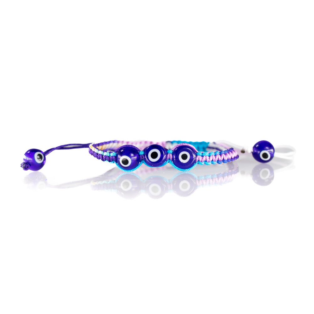 Macrame bracelet featuring three prominent dark blue evil eye beads on a vibrant purple and light blue braided cord with an adjustable closure