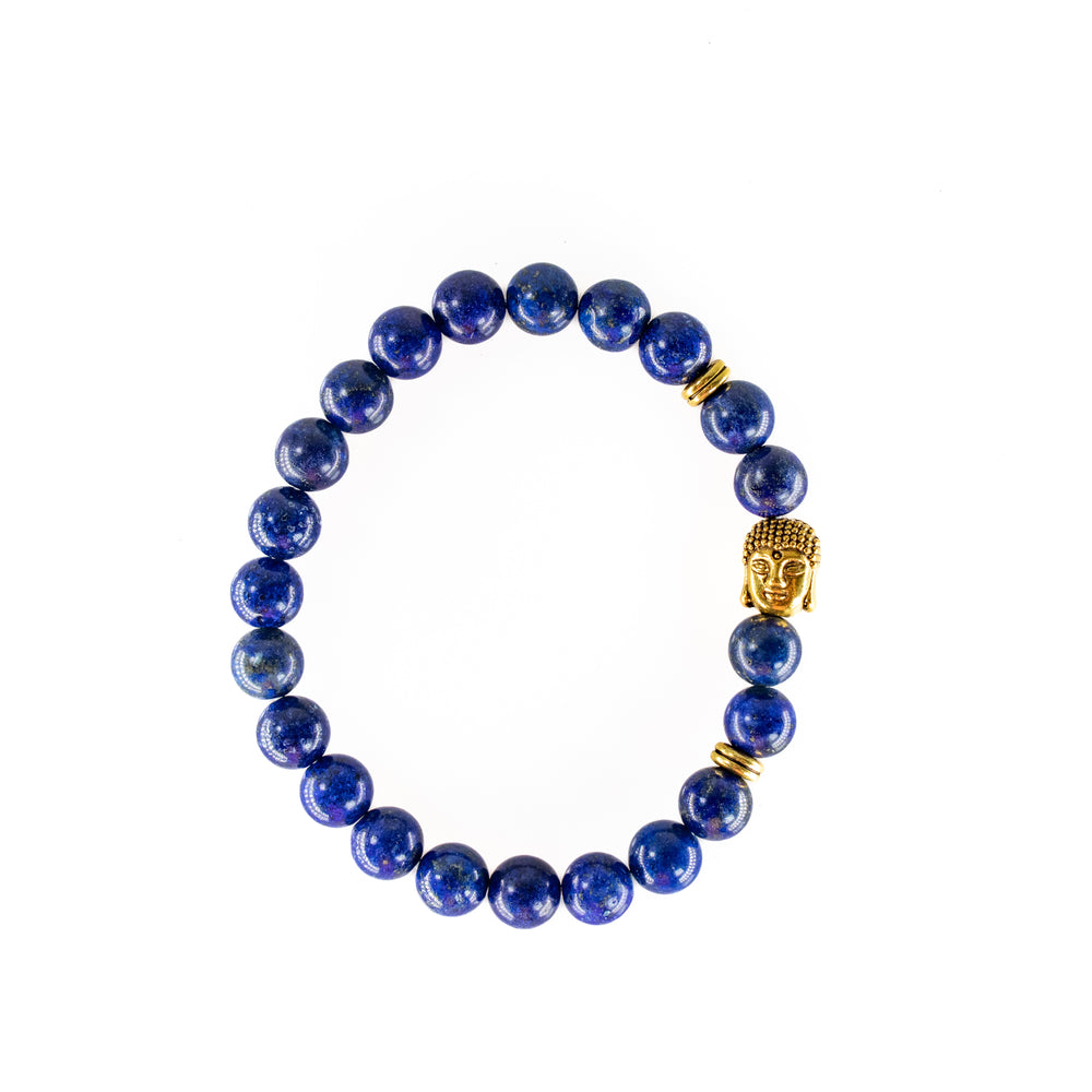 Beaded bracelet made of deep blue lapis lazuli beads adorned with a detailed gold-toned Buddha head charm and two small gold spacer rings