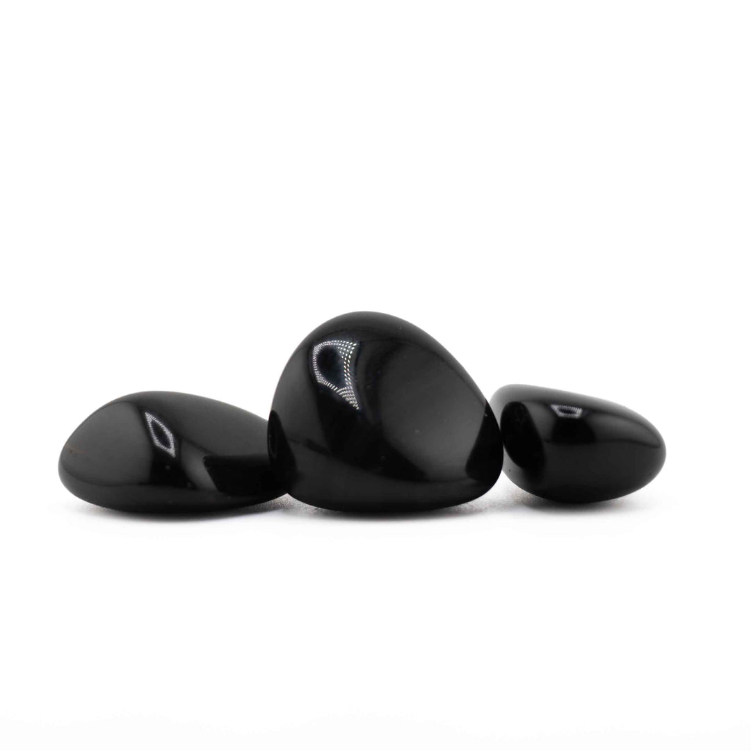 Group of three polished Black Obsidian tumbled stones displaying smooth finishes and natural pebble shapes
