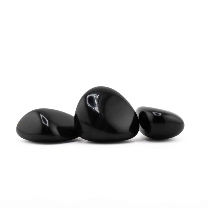 Group of three polished Black Obsidian tumbled stones displaying smooth finishes and natural pebble shapes