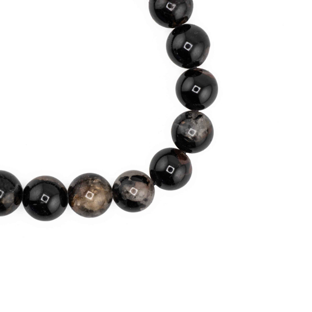 Close-up detail of round Black Tourmaline beads displaying glossy finish and natural brown and tan mineral veining