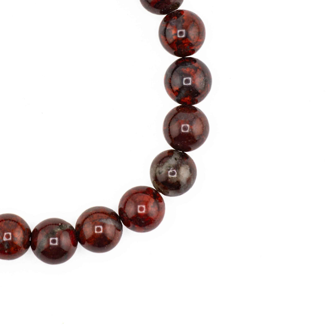 Close-up detail of smooth, round Bloodstone beads displaying rich crimson tones with subtle dark matrix specks