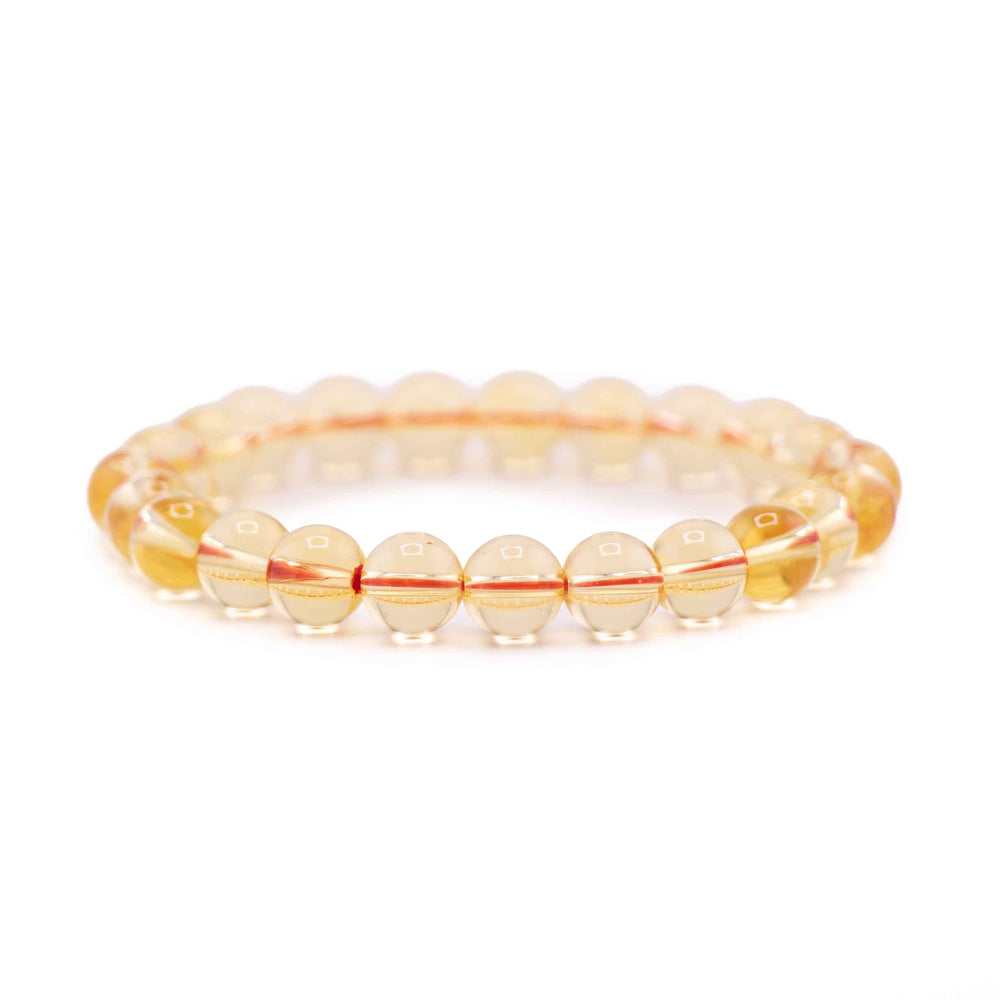 Side view resting shot of a clear yellow Citrine gemstone beaded stretch bracelet lying flat on a white background