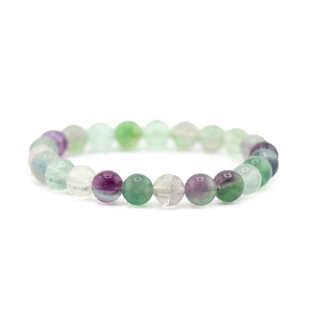 Side view resting shot of a Fluorite gemstone beaded stretch bracelet lying flat on a white background