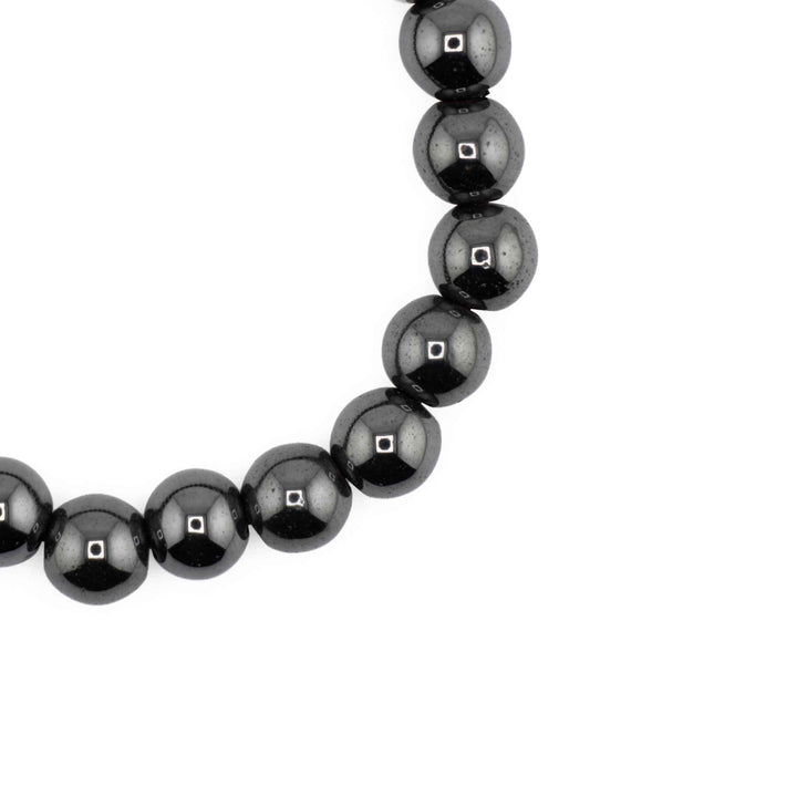 Close-up detail of glossy, round Hematite beads highlighting reflective metallic charcoal surfaces