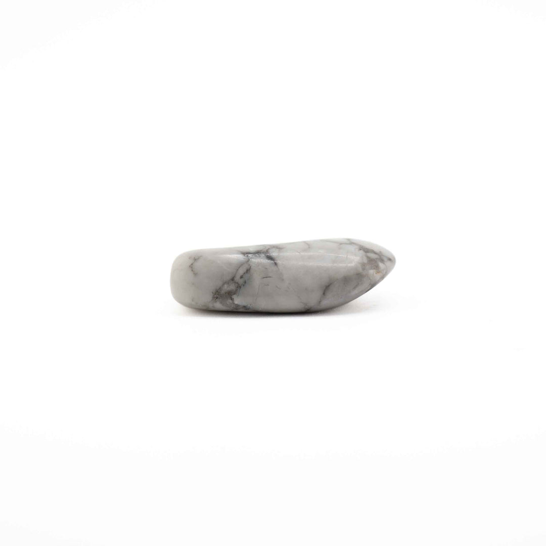 A single, elongated polished howlite tumbled stone positioned horizontally against a plain white background.