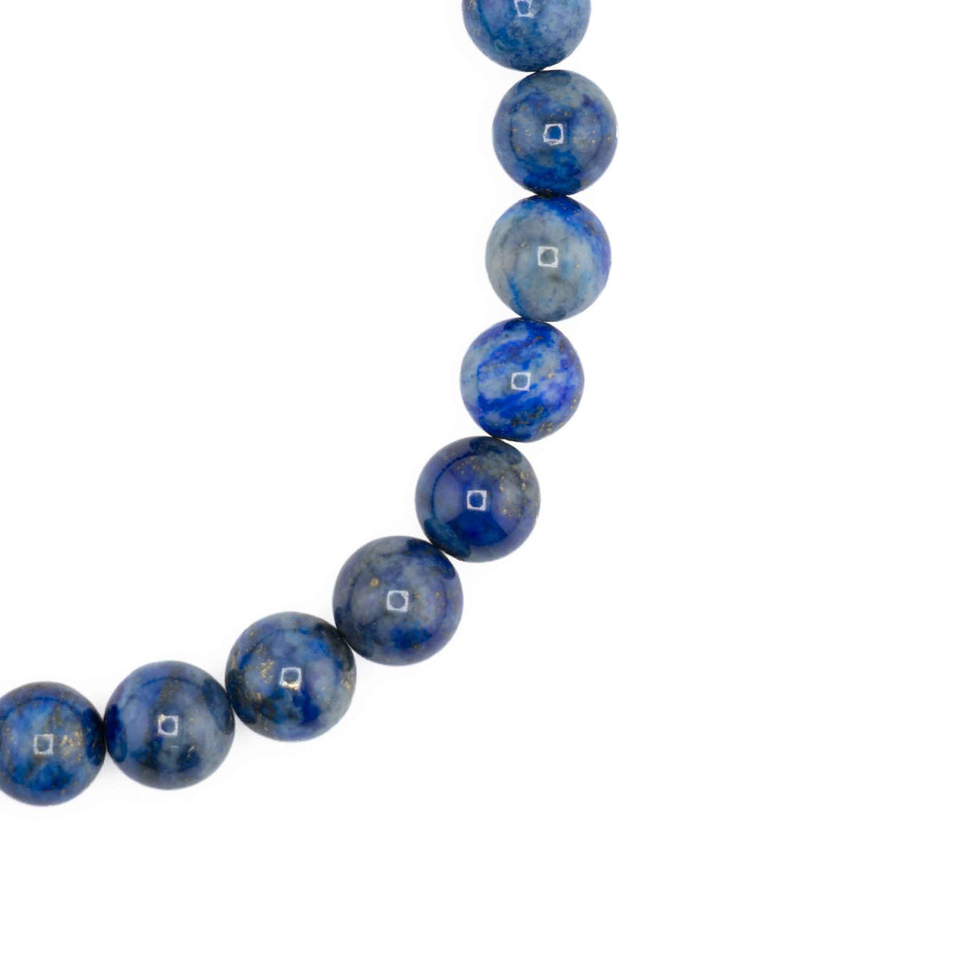 Close-up detail of smooth, round Lapis Lazuli beads showcasing natural golden pyrite flecks and blue color variations