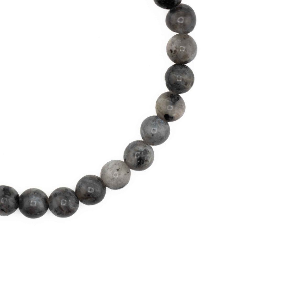 Close-up detail of smooth, round Larvikite beads highlighting silver-grey chatoyancy and natural mineral inclusions