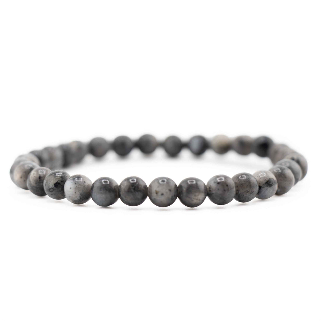 Side view resting shot of a dark grey Larvikite gemstone beaded bracelet on a white background