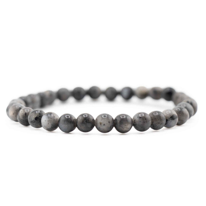 Side view resting shot of a dark grey Larvikite gemstone beaded bracelet on a white background