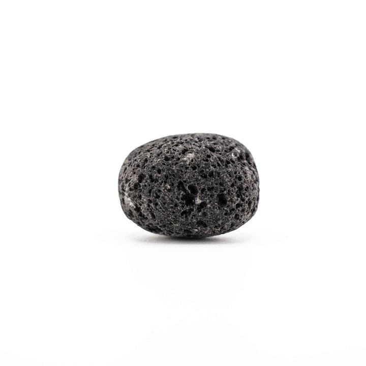 Smooth, rounded black lava stone tumbled crystal showing vesicular volcanic surface texture on a white background