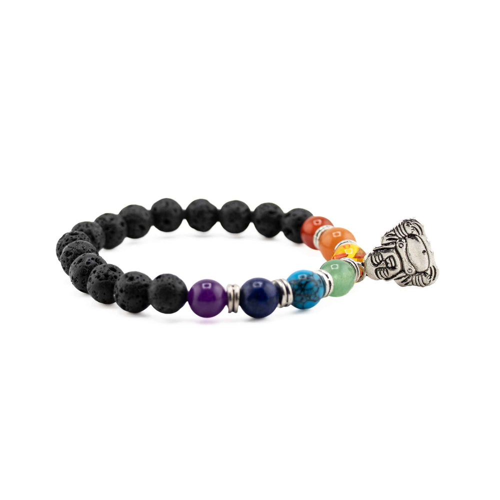 Side view resting shot displaying colorful chakra beads and a detailed silver Buddha head charm on a black lava stone stretch bracelet