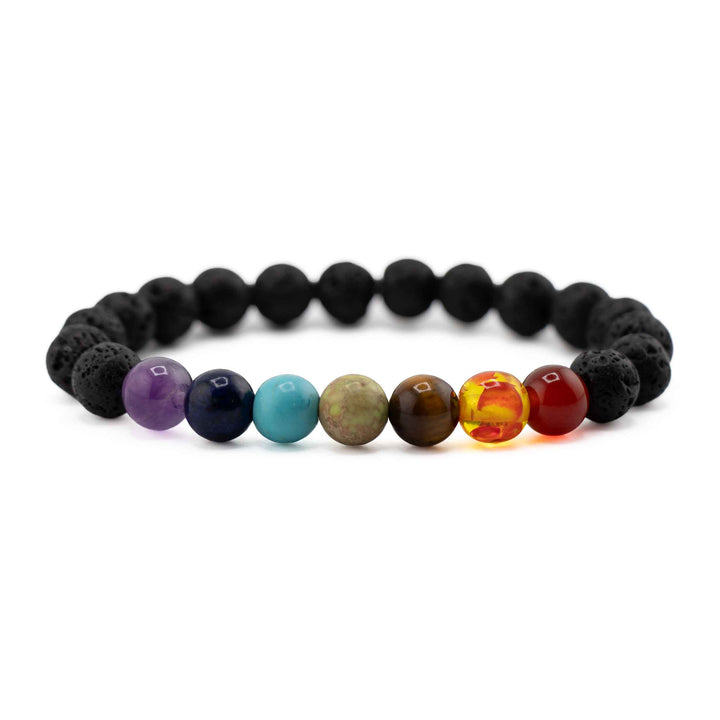 Side view shot resting on a white background highlighting seven colorful chakra beads centered on a black porous lava stone stretch bracelet