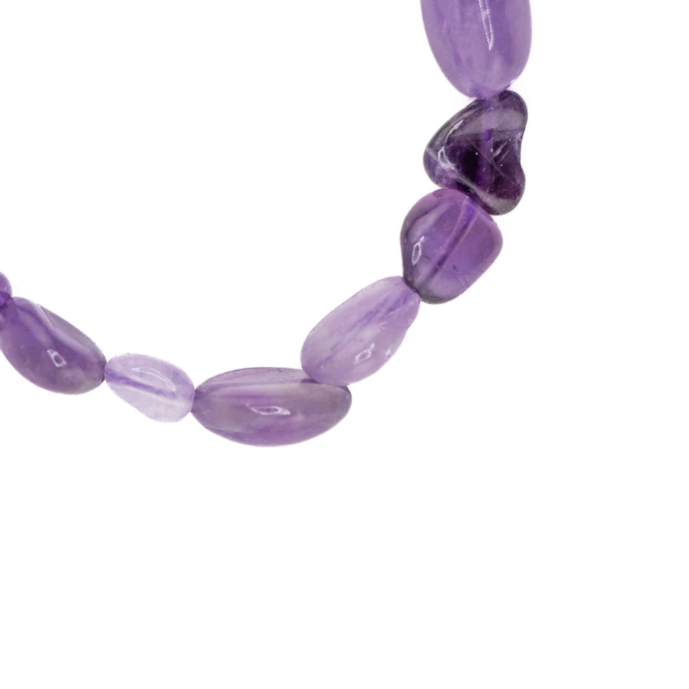 A close-up shot of several freeform Natural Amethyst gemstone chips, showcasing their unique organic shapes and varying shades of translucent purple.