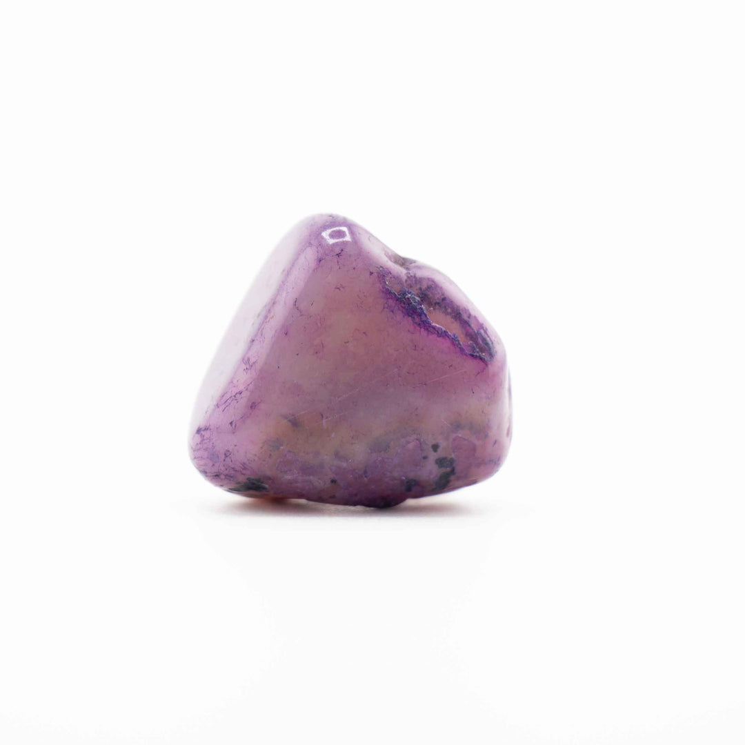 A single, smooth purple-dyed agate tumbled stone set centrally against a solid white background.