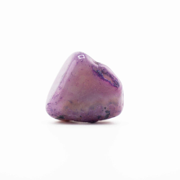 A single, smooth purple-dyed agate tumbled stone set centrally against a solid white background.