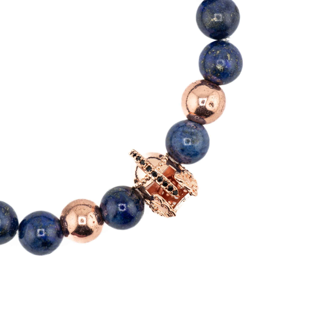 A side-angle, eye-level view of a Lapis Lazuli gemstone bracelet, showing the curve of the deep blue beads and the gold-colored helmet accent on a white background.