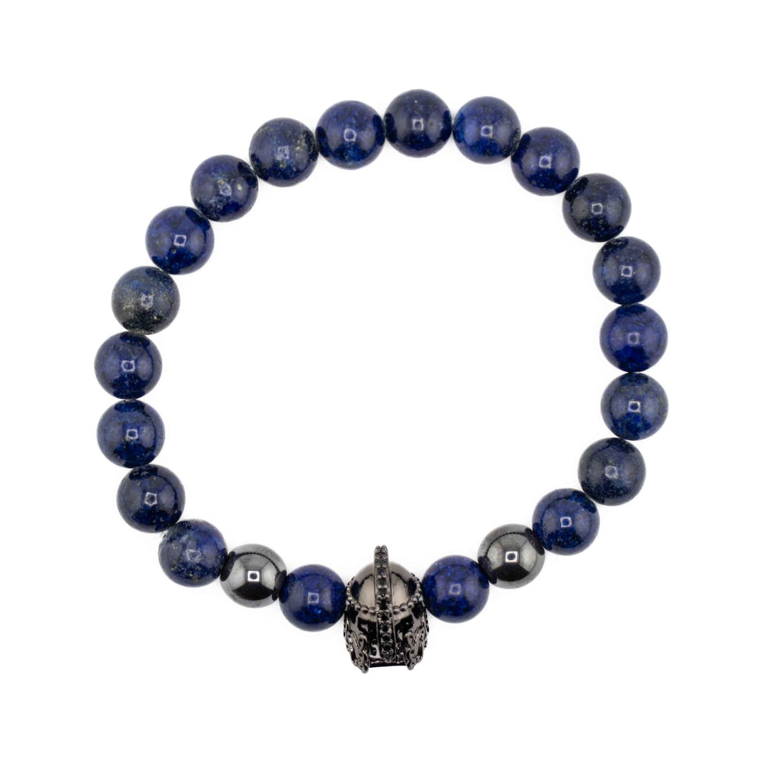 A top-down view of a Lapis Lazuli gemstone bracelet featuring round, deep blue beads and a central gold-colored ancient helmet accent bead on a white background.