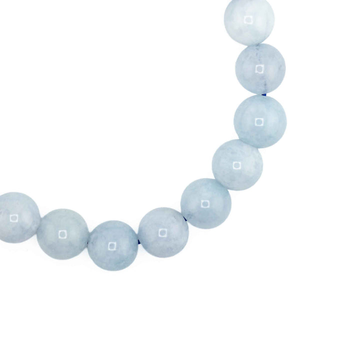 Close-up detail of polished round Aquamarine beads showcasing soft icy blue tones and gentle natural stone inclusions