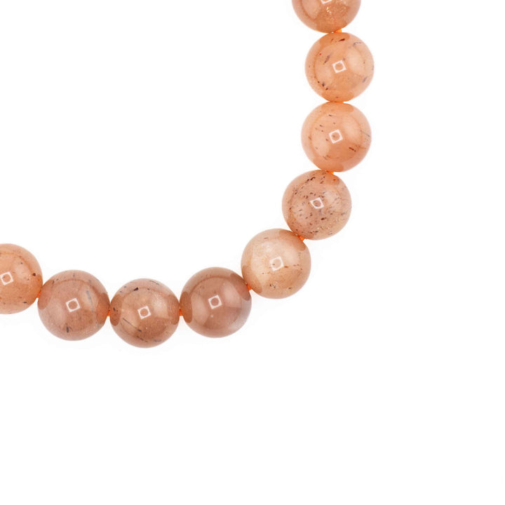 Close-up detail of polished round Peach Moonstone beads showing warm peach tones and subtle adularescence sheen