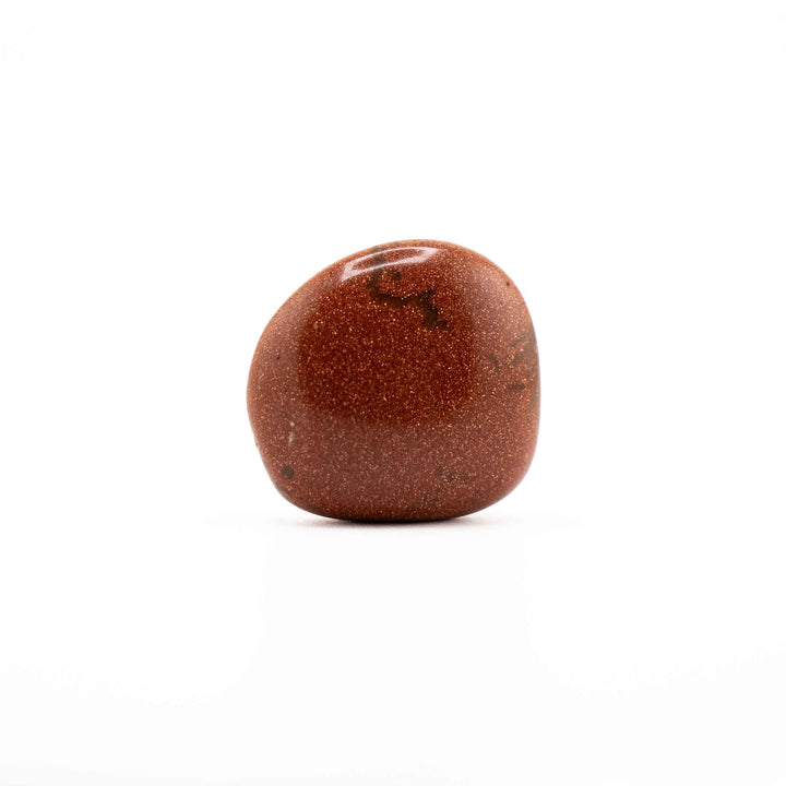 Smooth, rounded Red Goldstone tumbled crystal showing natural dark inclusions and sparkling metallic flecks on a white background