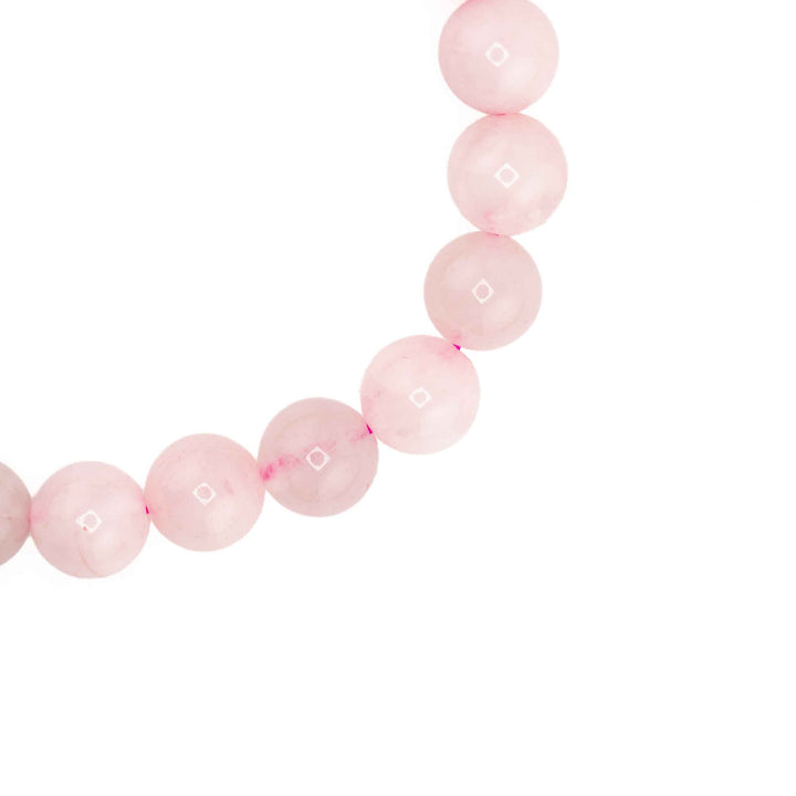Close-up detail of polished round Rose Quartz beads showcasing soft blush pink tones and delicate crystal clarity