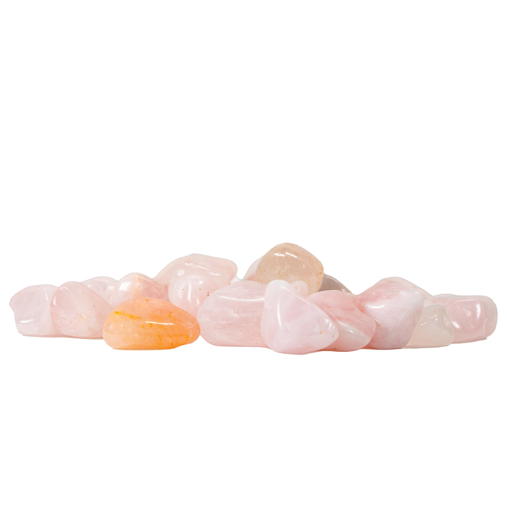 Photograph of a small pile of rounded, smooth semiprecious stones featuring pale pink rose quartz and one distinct peachy-orange stone on a white background