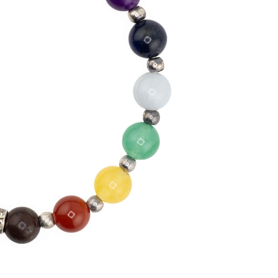 Close-up view of vibrant chakra beads separated by silver spacers on a golden Tiger Eye stretch bracelet