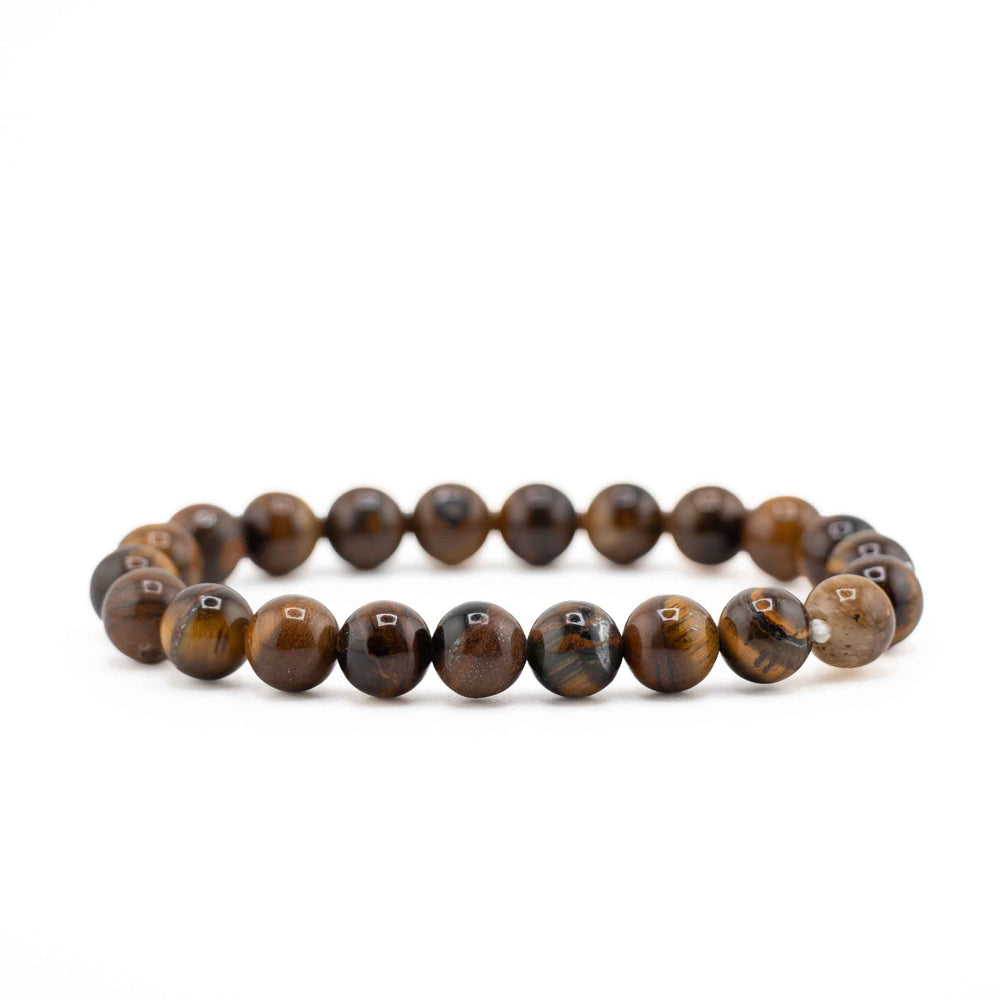 Side view resting shot of a natural Tiger Eye beaded stretch bracelet showing golden-brown chatoyant gemstone spheres