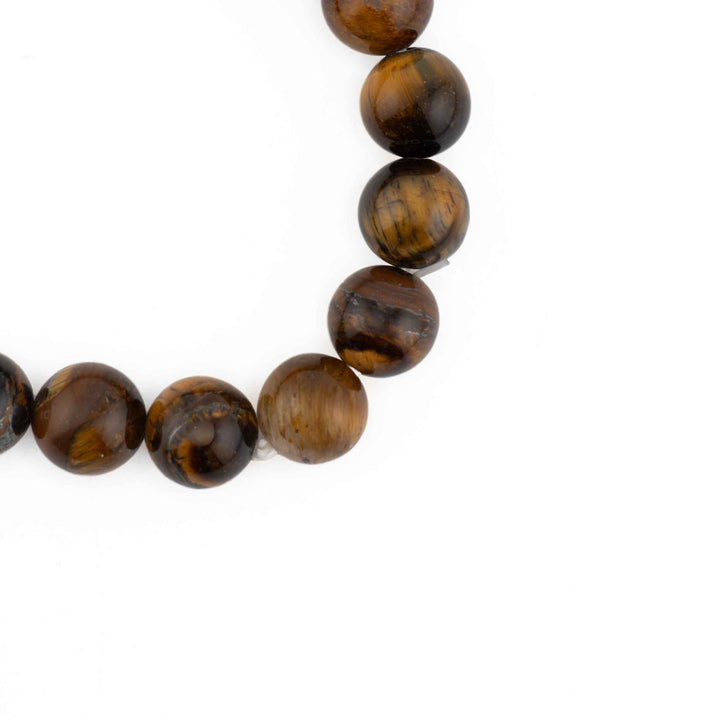 Close-up detail of smooth, round Tiger Eye beads highlighting natural silky lustre and rich amber-brown bands