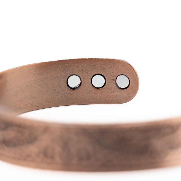 Rose copper bracelet with three silver beads on a white background