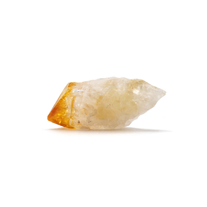 A raw citrine crystal point showing a translucent pale yellow body with a warm golden-orange heated tip, photographed on a clean white background.