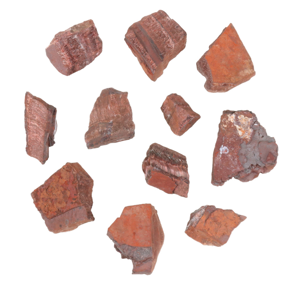Raw reddish-brown mineral fragments on a white background displaying distinct fibrous banding, rough earthy textures, and occasional grey inclusions