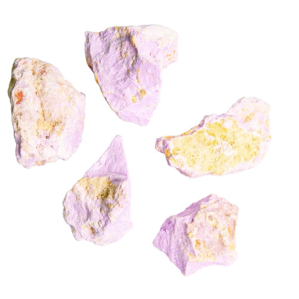 Photograph of five irregular jagged mineral rocks displaying vibrant lavender purple and textured golden yellow patches against a stark white background